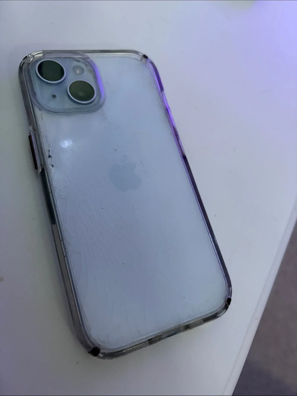 Apple iPhone 15, light blue with clear case.